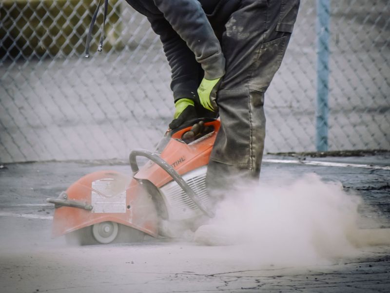 Worker cutting pavement with a concrete saw, tool rental in McGehee, AR