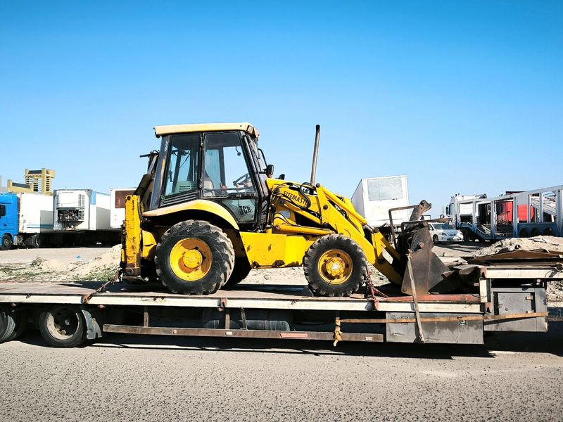 Backhoe loaded on an equipment hauling trailer, trailer rental in McGehee, AR